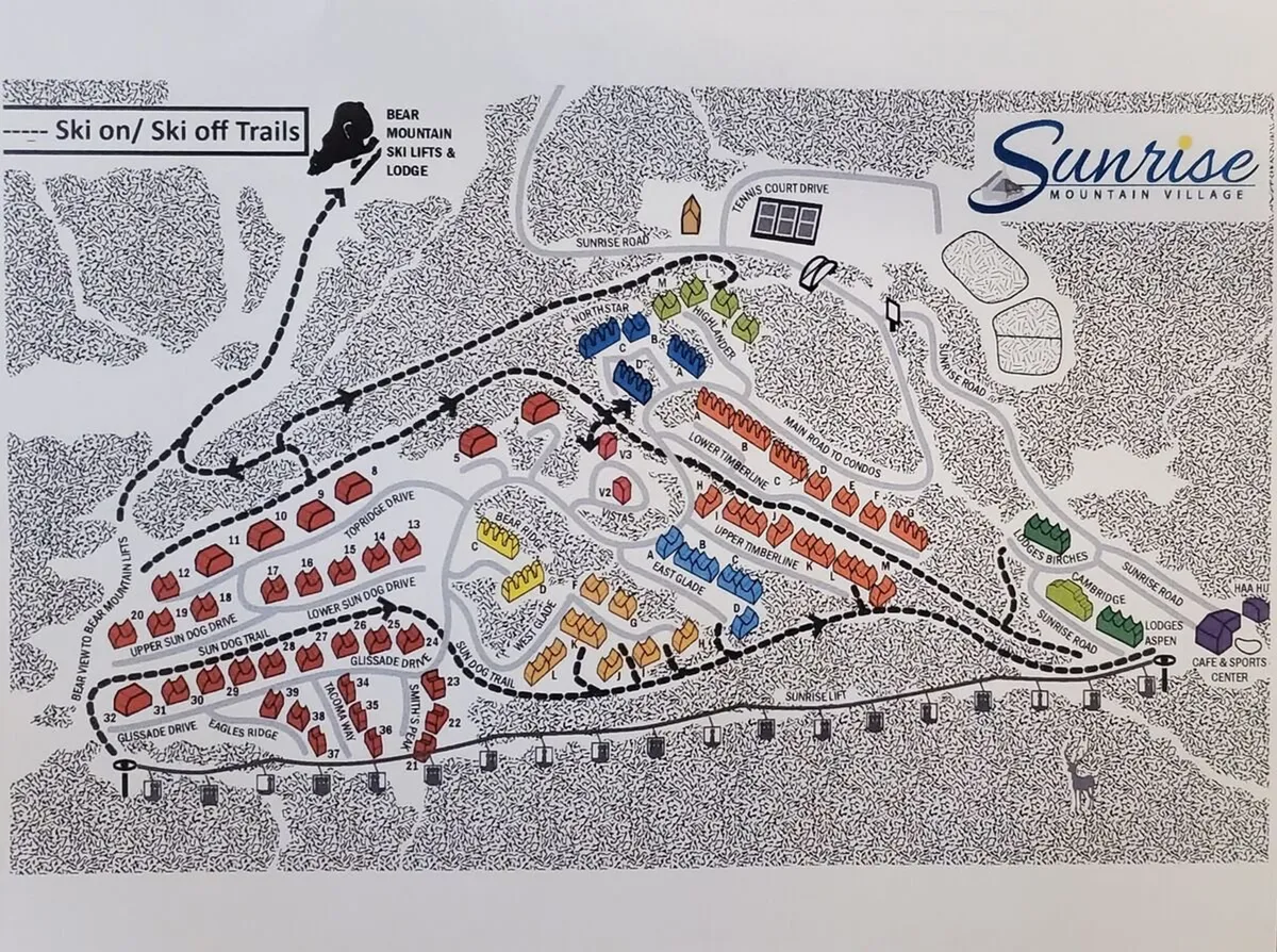 A wide-angle view of ski trails, mountain lodges, Bear Mountain ski lifts, and bustling village amenities. Active skiers and snowboarders can be seen enjoying the slopes, with the community and lift infrastructure underscoring the ski-in/ski-out convenience.